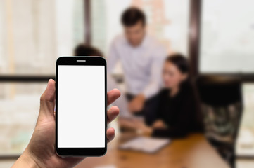 Hold  mobile on the background of a group of business people working in an office.