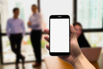 Hold  mobile on the background of a group of business people working in an office.