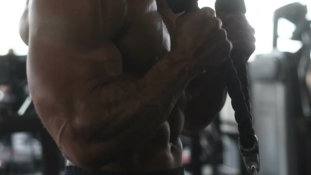 Handsome young fit muscular caucasian man of model appearance workout training in the gym gaining weight pumping up muscle, poses, drinks water  fitness and bodybuilding sport nutrition concept