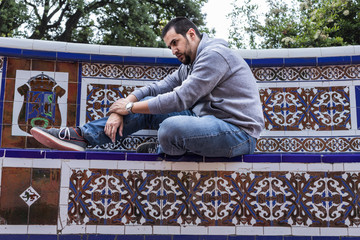 Fototapeta premium hombre sentado en banco de azulejos arabes