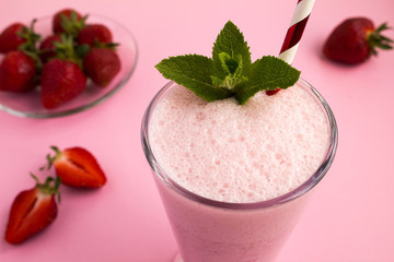 Strawberry milkshake in the glass on the pink  background.Closeup.