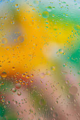 Liquid texture abstraction. Particles of oil and water with a strongly colored blurred background. The color of the holiday. Explosion of liquid