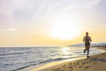 Fototapeta na wymiar Healthy young fitness woman runner running on sunrise seaside trail