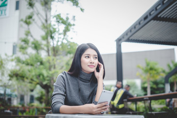 Fototapeta premium Portrait of young businesswoman use mobile phone while sitting in comfortable coffee shop during work break, charming happy female reading fashion news on cell telephone