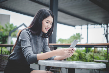 Portrait of young businesswoman use mobile phone while sitting in comfortable coffee shop during work break, charming happy female reading fashion news on cell telephone