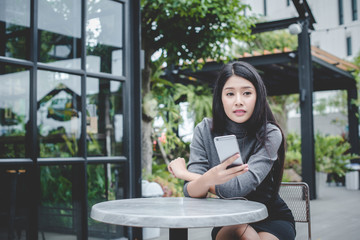 Portrait of young businesswoman use mobile phone while sitting in comfortable coffee shop during work break, charming happy female reading fashion news on cell telephone