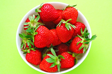 Fresh ripe strawberries in a bowl. Bright background.