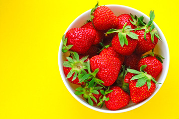 Fresh ripe strawberries in a bowl. Bright background.