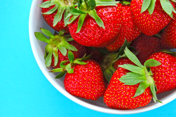 Fresh ripe strawberries in a bowl. Bright background.