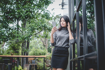Portrait of young businesswoman use mobile phone while sitting in comfortable coffee shop during work break  charming happy female reading fashion news on cell telephone