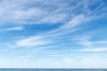Ingelijste posters Mooie blauwe lucht boven de zee met doorschijnende, witte, cirruswolken © Aleksandr Simonov