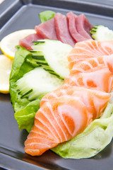 tuna and salmon sashimi on black dish