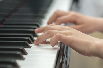Obraz premium children's hands are playing the piano. Child's hand on piano keys.