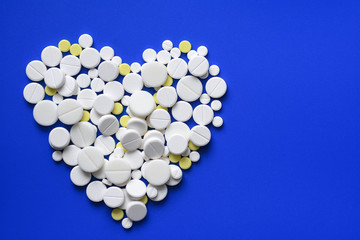 Round tablets arranged abstract isolated on blue color background. Pills for design. Concept of...