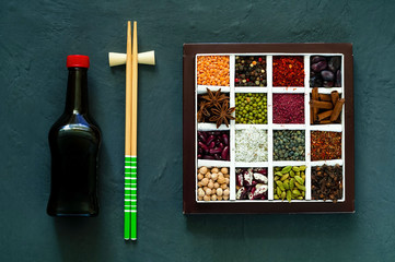 The concept of cereals organic products and spices on dark concrete background. Seasonings for eating,beans for cooking,healthy diet, choice of clean food, copy space, closeup,top view.