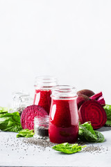 Healthy and healthy detox smoothies or juice from raw beets and spinach with chia seeds in glass bottles on a gray background, selective focus