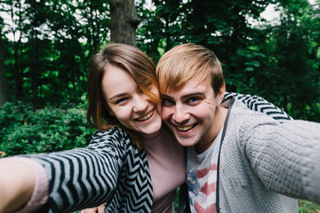 Fototapeta premium Two lovers walk around the park, kiss and hug, a love story.