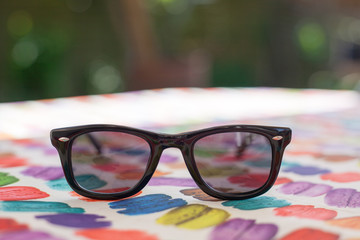 Sunglasses on a table with colorful tablecloth