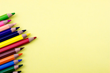 Color Pencils set on yellow tone color paper. Empty space for text and design. Minimalism concept