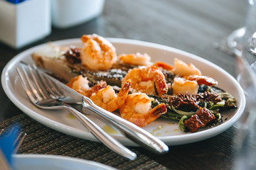 salad with Royal shrimps on a white plate.