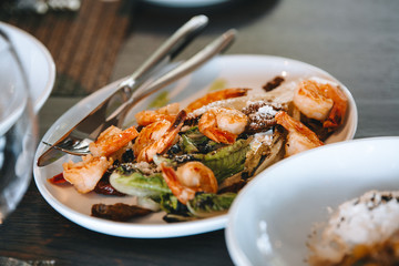 salad with Royal shrimps on a white plate.