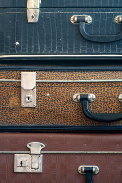 Three old suitcases on top of each other. Close up.