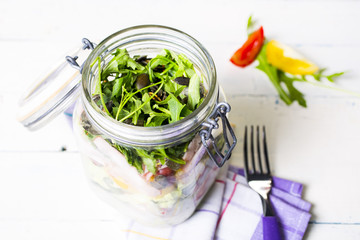 Salads with arugula  radish  tomatoes  seeds and cucumber in glass jars. Healthy food  diet and detox concept