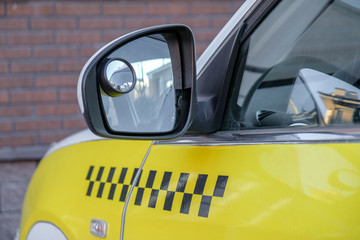 Rear view mirror on yellow taxi cab