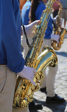 musician with white gloves playing a saxophone during a parade