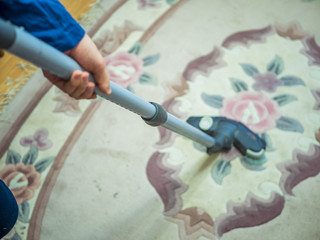 close up hand holding vacuum cleaner on the carpet in the room