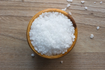 Fototapeta na wymiar Top view of Salt or sea salt in a wooden bowl on a wooden table background.