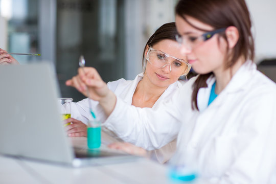 Two young female researchers carrying out experiments in a lab (shallow DOF; color toned image)