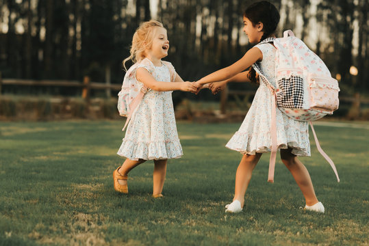 Girls Twirling With Backpacks