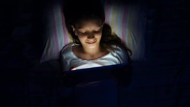 digital modern device addiction. gadget night sleeplessness. young caucasian girl browsing chatting playing serfing network with tablet bed. mobile phone apps.