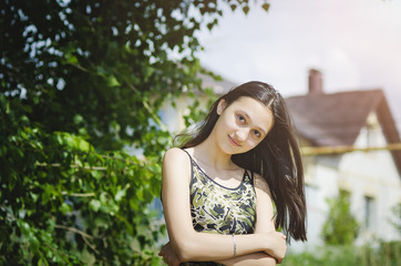 Beautiful teen girl on a green tree background.