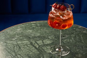 Tomato sprits cocktail on bar counter table. Refreshing Twist classic cocktail with Tomatoes, Aperol, Proseco and soda top, close-up