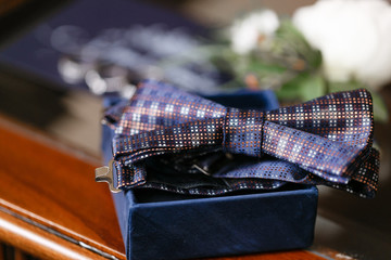 Grooms morning. Wedding accessories. Blue butterfly-tie, cufflinks and boutonniere