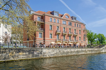 Fototapeta na wymiar Bank of the river Spree Schiffbauerdamm with the building of Ida-Simon foundation