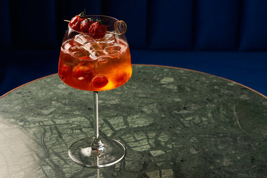 Tomato sprits cocktail on bar counter table. Refreshing Twist classic cocktail with Tomatoes, Aperol, Proseco and soda top, close-up