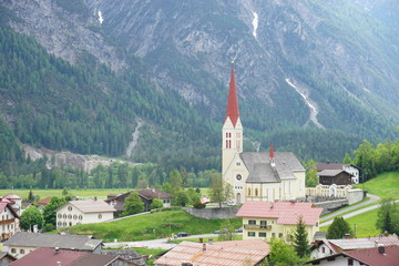 Panorama in Österreich mit traditionellen Häusern und der Kirche des Dorfs Lech in Holzgau