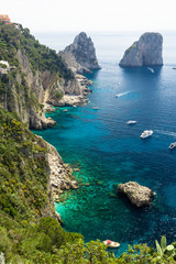 Capri Island, Italy - April 29 2018: Boats cruise in the turquoise Water of the beautiful Coastline of Capri