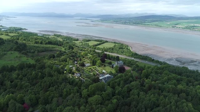 Aerial footage flying over woodland from a large country house and gardens near the village of Langbank on the south shore of the Firth of Clyde.
