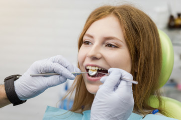 Dentist examining girl's teeth in clinic. Dental problem. Healthy Smile.