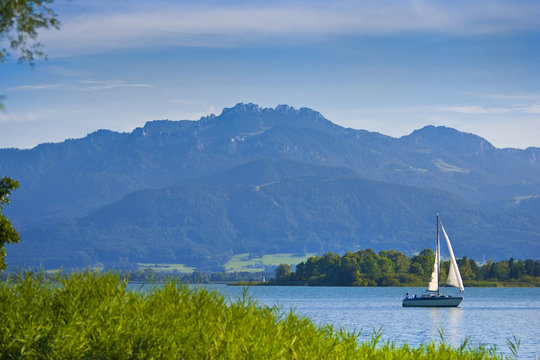 Segelboot auf dem Chiemsee in Bayern mit Berg Kampenwand