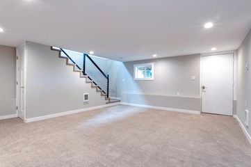 Light spacious basement area with staircase. - obrazy, fototapety, plakaty