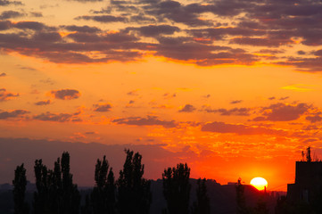 Landscape with dramatic light - beautiful golden sunset with saturated sky and clouds.