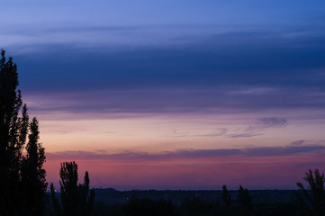 Landscape with dramatic light - beautiful golden sunset with saturated sky and clouds.