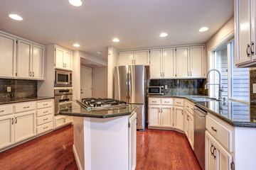 White kitchen room with stainless steel appliances.