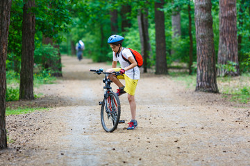 Naklejka premium nice cute young 11 year boy in helmet rides a bike in the summer. selective focus. sport lifestyle concept for kids