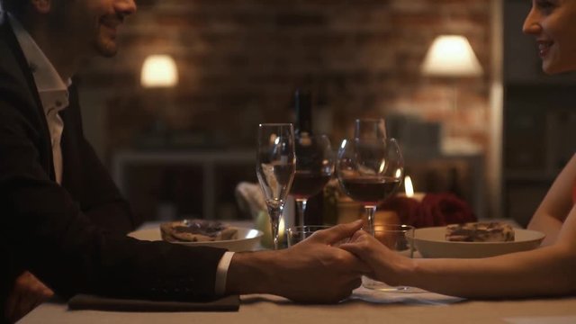 Romantic couple dining together and holding hands